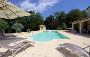Beaumont-du-PérigordVilla "Duxcaar"的一个带两把椅子和遮阳伞的游泳池