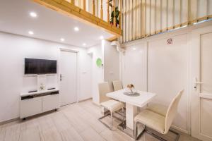 斯普利特Apartment Duci的厨房以及带白色桌椅的用餐室。