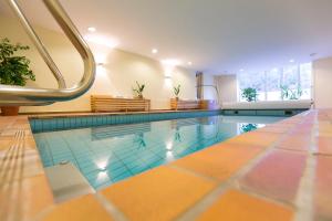 波鸿罗腾塔尔沃尔德高尔夫酒店 的一座大型游泳池,铺有瓷砖地板