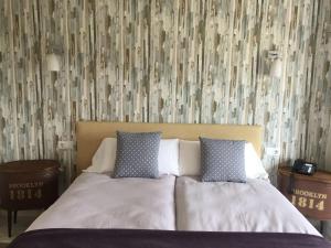 贝赫尔-德拉弗龙特拉Hotel Nómadas的卧室内的一张带两个枕头的床,配有壁纸