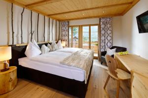 格林德尔瓦尔德阿斯彭阿尔卑斯休闲酒店的一间卧室配有一张大床和一张书桌
