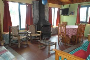 皮什丹吉Cabañas Los Tamarugos的客厅设有壁炉、桌子和椅子