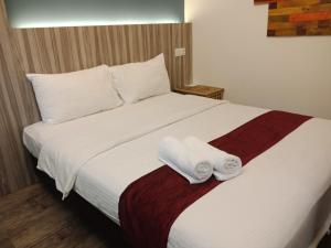 八打灵再也The Verve Hotel PJ Damansara的一间卧室配有一张床,上面有两条毛巾