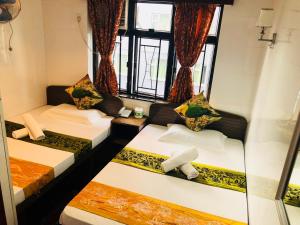 香港旅客宾馆的带三张床和窗户的客房
