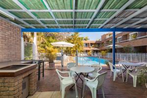 科夫斯港阿曲亚吉汽车旅馆的一个带桌椅的庭院和一个游泳池