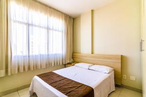 贝洛奥里藏特Villa Neves Residence的一间卧室设有一张床和一个大窗户