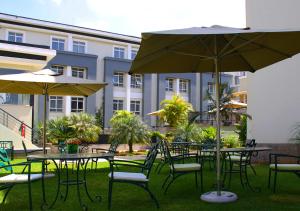 内罗毕内罗毕依卡酒店的一组桌椅和一把伞