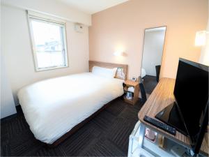 弘前市Super Hotel Hirosaki的酒店客房,配有床和电视