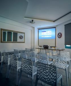 卡特瑞杜斯尼古拉斯酒店的一间带椅子和屏幕及演示的房间