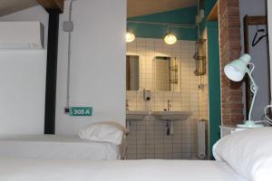 昆卡Green River Hostel的客房设有两张床和一间带水槽的浴室