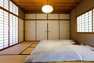 京都Konuka Yakushi Temple House的一间带一张大床的卧室,位于带窗户的房间内