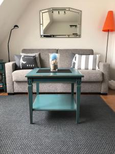 韦斯特兰Kastanienhüs Apartment的带沙发的客厅内的蓝色咖啡桌