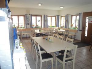伊森塔尔乌里罗斯托酒店的用餐室设有桌椅和窗户。