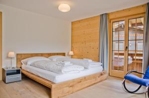 格林德尔瓦尔德Apartment Bränderli - GRIWA RENT AG的一间卧室设有一张带木墙的大床