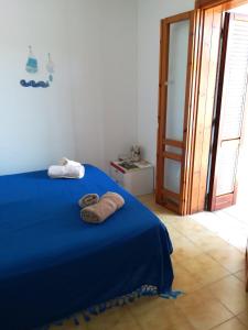 托里德欧索Camera Torre Dell'Orso的一间卧室配有蓝色的床和毛巾