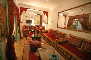 马拉喀什谢里哈尼摩洛哥传统庭院住宅的客厅配有红色的沙发和镜子