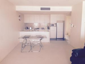 Port AdelaideBreakwater Apartment的厨房配有桌椅和冰箱。