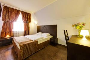 顿河畔罗斯托夫维拉洛萨酒店的一间卧室配有一张床、一张书桌和一个窗户。
