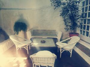 艾西拉帕蒂奥德拉露娜旅馆的庭院设有藤椅、桌子和桌椅