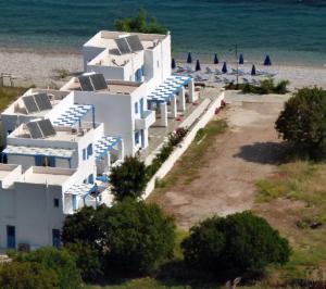 里瓦的亚梦之岛公寓式酒店的海滩上一群白色的建筑,上面有遮阳伞