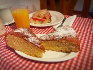 安索Casa Úrsula的桌上盘子上的两片蛋糕和橙汁
