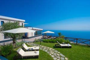 阿杰罗拉Villa Paradise Resort的一座房子,配有两把草坪椅和一把伞