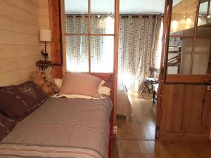 普华露Appartement chalet PRA LOUP 1600 La sapinière的卧室配有一张带泰迪熊的床,毗邻窗户