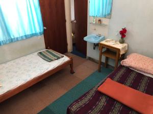 武吉丁宜Astani Family Home的小房间设有两张床和盥洗盆