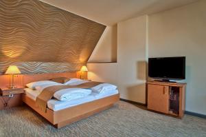 维也纳科尔蒂纳丹俱乐部酒店的一间卧室配有一张床和一台平面电视