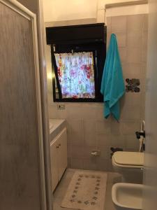 卡斯蒂里昂纳·德拉佩Appartamento Porto Prile CastiglioneD.P.的一间带卫生间的浴室和一个带窗帘的窗户