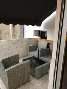 瓦朗斯雷莱南酒店的庭院配有藤椅、桌子和电视。