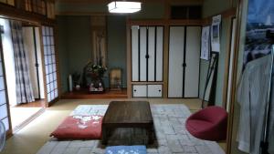 阿苏市Guesthouse Taihei的客厅配有木桌和红色椅子