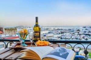 萨莱诺MARGHERITA's Apartment的一本书和一张桌子上的一瓶葡萄酒和眼镜