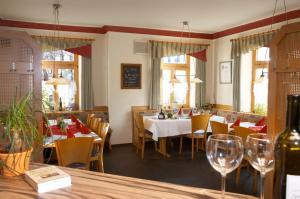 Wettelsheim加思索夫尊金德恩兰姆酒店的用餐室配有桌椅和酒杯