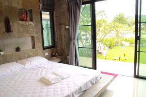 坤西育府Angie Resort at Nakhon Nayok的卧室设有白色的床和大窗户