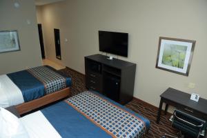Prairieville Americas Best Value Inn & Suites-Prairieville的酒店客房设有两张床和一台平面电视。