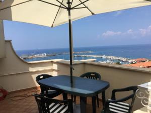 维博瓦伦蒂亚码头Villa Angelica的阳台配有蓝色的桌椅和遮阳伞