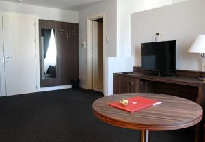 卡斯泰尔佩特罗索拉丰特戴拉斯托雷酒店的一间酒店客房,配有一张红色文件夹的桌子