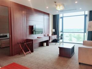 土龙木市Becamex Hotel New City的酒店客房设有一张书桌和一个大窗户。