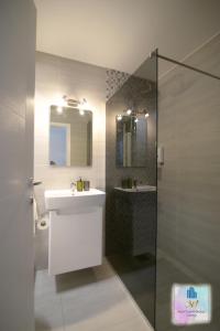 斯科普里3M Apartment Skopje Center的一间带水槽、镜子和淋浴的浴室