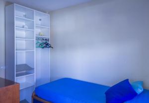 厄尔梅达诺Rooms in El Medano的一间卧室配有蓝色的床和架子