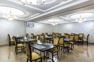 阿拉木图皇家公园酒店的一间在房间内配有桌椅的餐厅