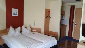 维斯洛赫伊芬酒店的一间卧室配有带白色枕头的床