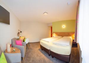 斯图加特阿森贝格酒店的配有一张床和一把椅子的酒店客房
