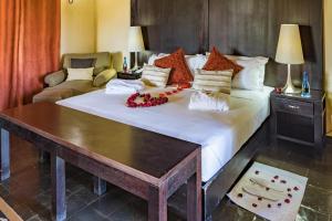 拉塞利亚Shumba Valley Lodge的一间卧室配有一张带鲜花的大床