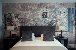 利物浦马尔马逊利物浦酒店的一间卧室配有一张带两盏灯和一堵墙的床。