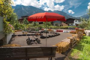 迈尔霍芬Apart Central – Premium Mountain&Garden的停车场里的红伞,装有滑板车