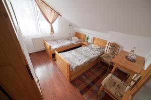 Rajecká LesnáHostinec u Hromadov - ubytovanie v súkromí的一间卧室设有两张床、一张桌子和一个窗口