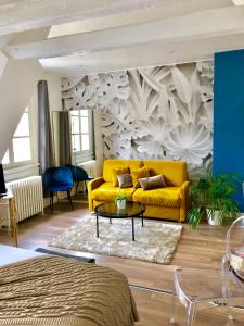 斯特拉斯堡LIFE RENAISSANCE - New Concept - Place Kléber的客厅里一张黄色的沙发,墙上挂着
