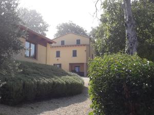 托迪Agriturismo Il Truffarello TODI的前面有灌木丛的大黄房子